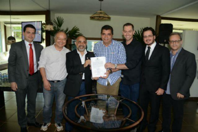 Prefeito de Palmas, Carlos Amastha (azul), e o Ministro dos Esportes, George Hilton (terno), seguram documentos licitatórios do BRT