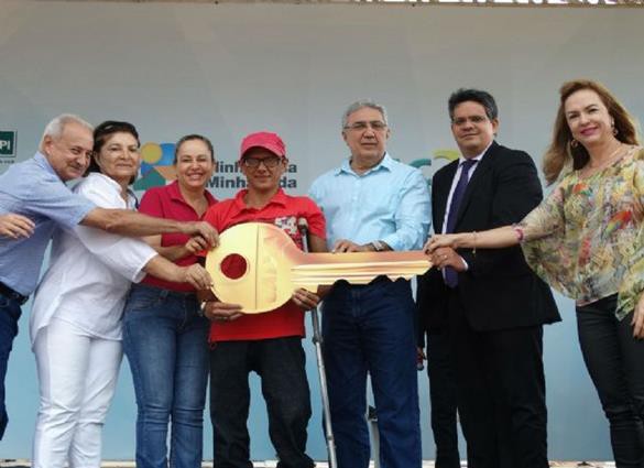 Prefeito Laurez Moreira (centro/azul) repassa chave de nova moradia à beneficiado do programa 
