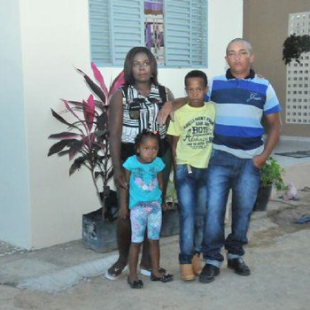 Beneficiada posa para foto em frente a casa nova