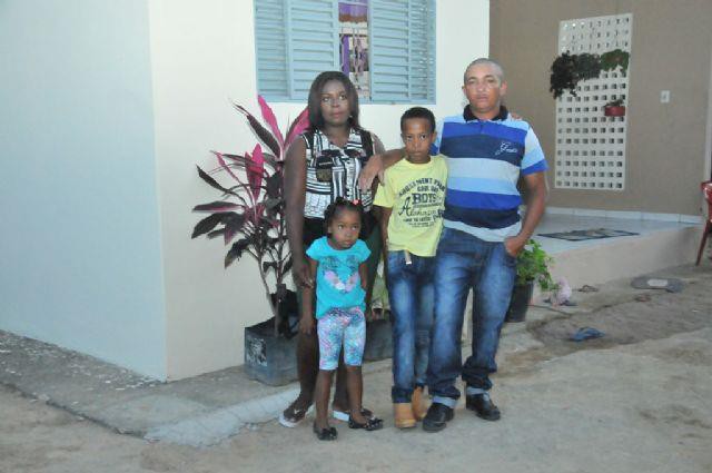 Beneficiada posa para foto em frente a casa nova
